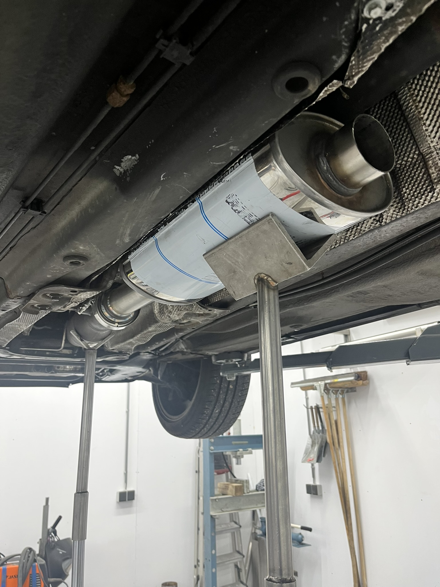 Een demper wordt met steunen onder de Volvo op zijn plek gehouden; één aansluiting is nog open