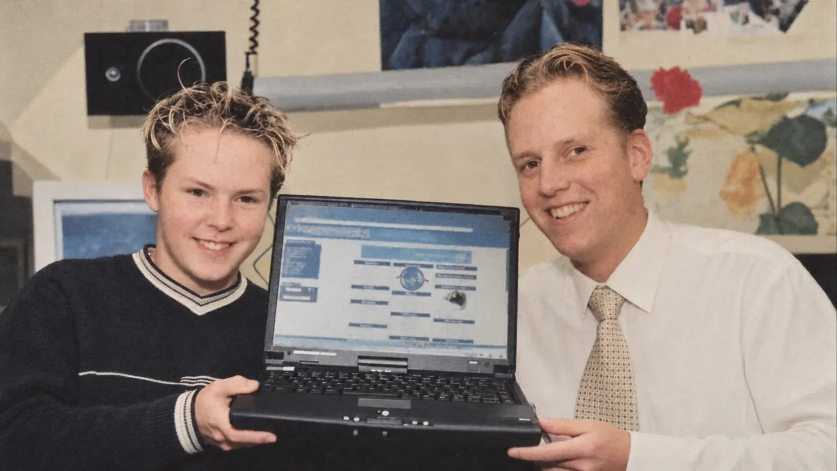 Joris Hartsuiker en Arjan Stroeve poseren samen met een laptop waarop een van hun vroege websites te zien is